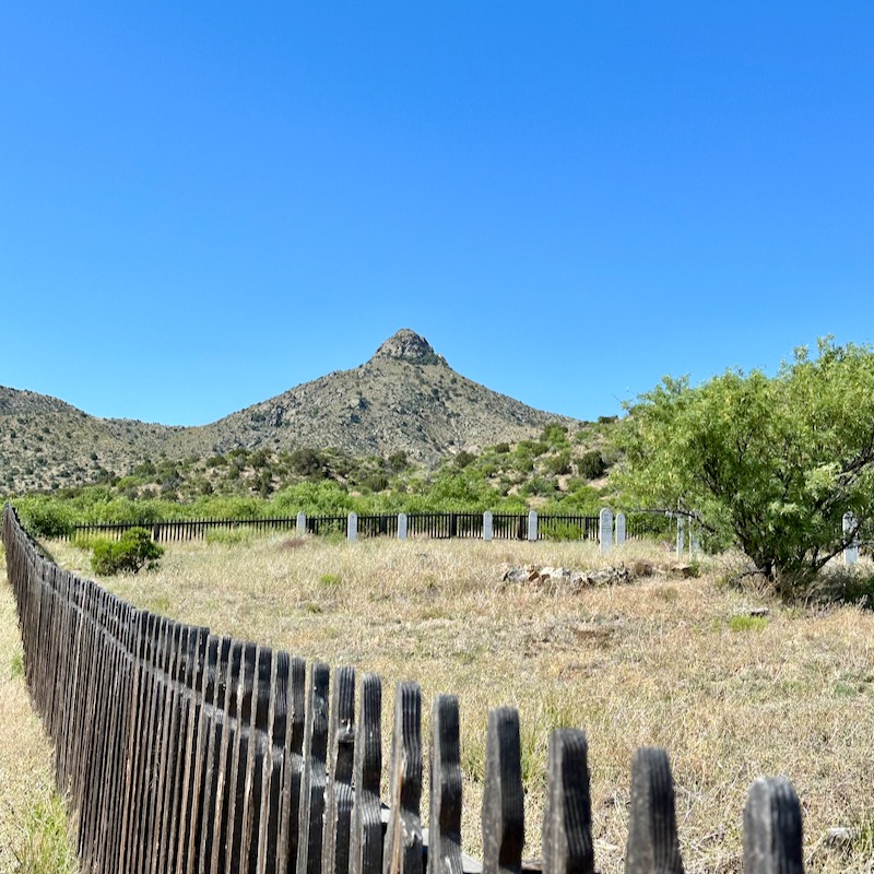 Photo of Ft. Bowie cemetery with fence in foreground and mountain in background